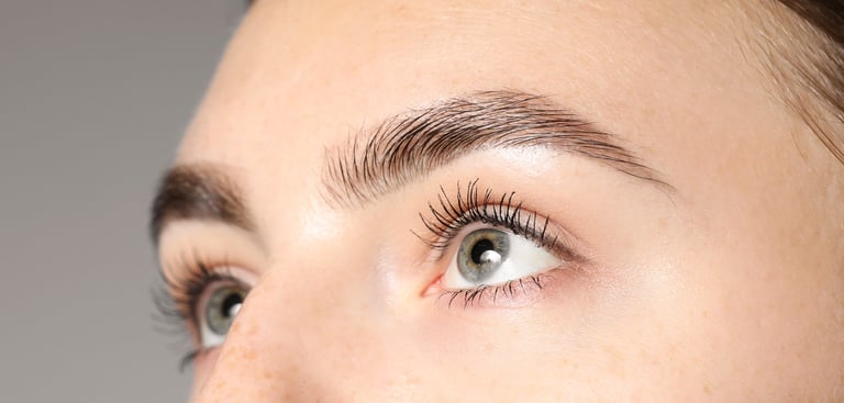 Close-up of a woman with beautifully shaped, natural-looking permanent eyebrows after treatment