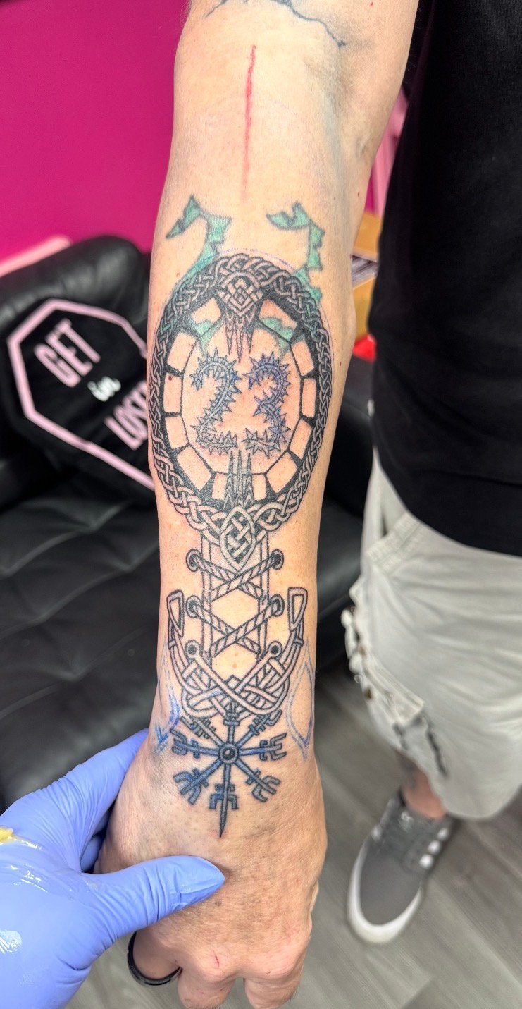 Person displaying a Celtic-inspired tattoo on their forearm featuring an ornate circular design with intricate knotwork patterns