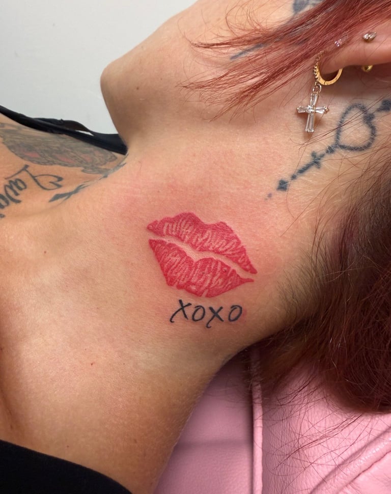 Neck tattoo featuring red lips and xoxo text, with piercings and other body art visible