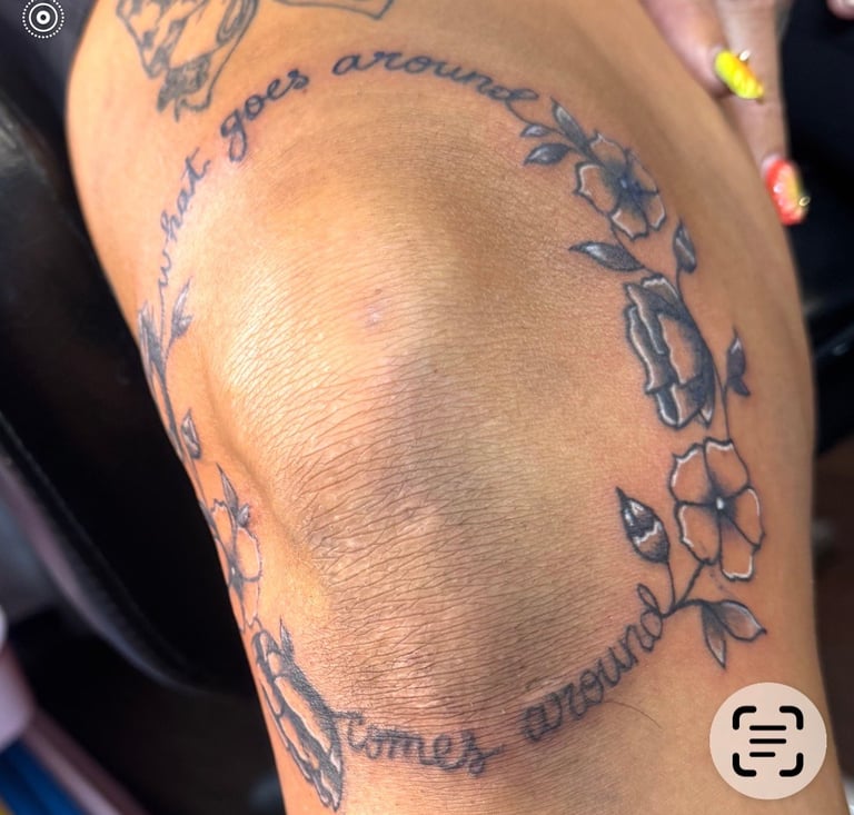 Arm tattoo featuring a large oval frame with floral designs and cursive text around the border