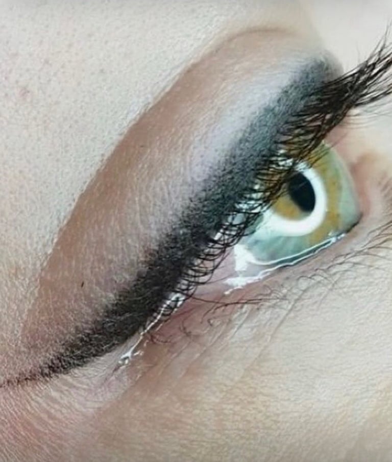 Close-up of an eye with green-hazel iris, featuring dark eyeshadow, defined black eyeliner, and full black lashes at CC Styling Studio Bradenton FL