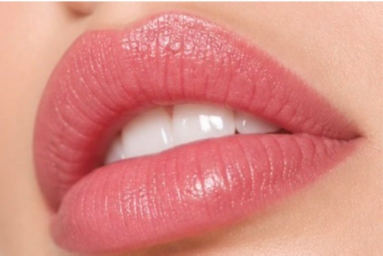 Close-up of full lips with dusty rose pink lipstick and glossy finish