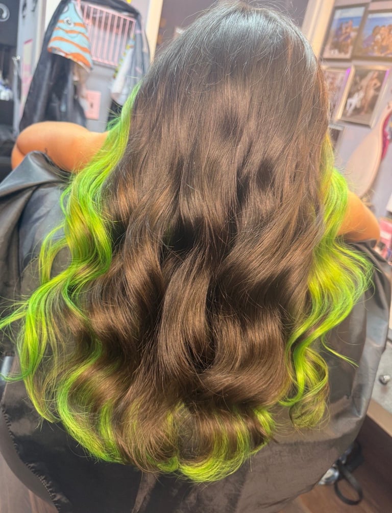 Back view of long wavy hair with brown base and neon yellow-green underneath layers and ends in Bradenton, Florida by CC Styling Studio