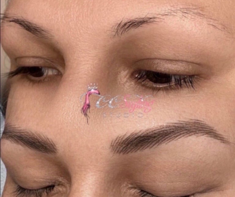 Close-up of a persons face with eyes closed showing a pink and purple decorative temporary tattoo on their nose