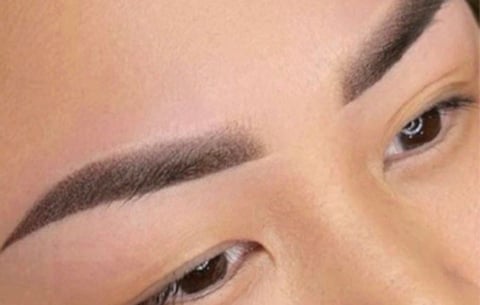 Close-up of a womans face showing defined eyebrows and eye makeup