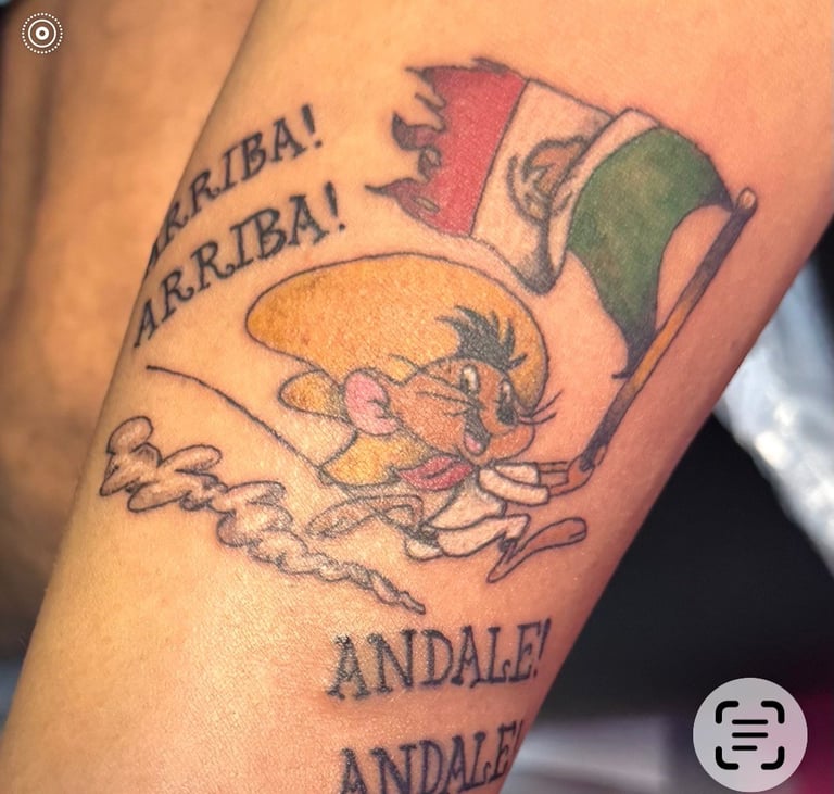 Tattoo on arm featuring a bull, Italian flag, and text reading Arriba and Andale