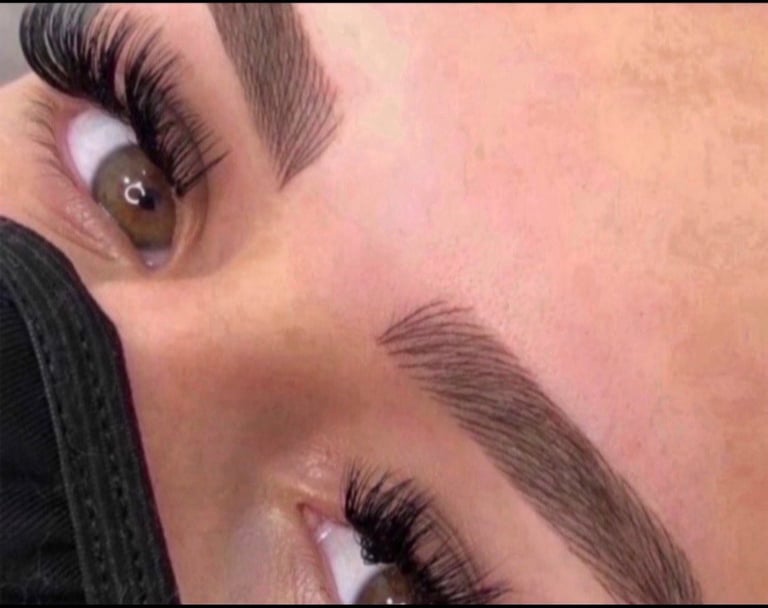 Close-up of a womans face showing dramatic black false eyelashes and defined eyebrows