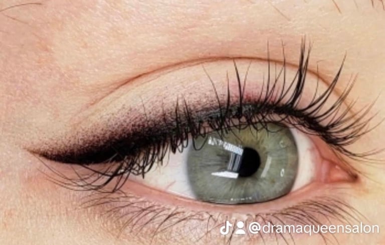 Close-up of an eye with winged eyeliner makeup, gray-green iris, and thick black false lashes at CC Styling Studio Bradenton FL
