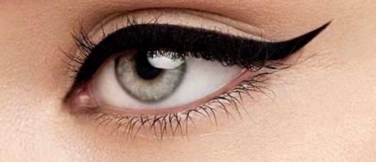 Close-up of a womans eye with gray iris, dramatic black winged eyeliner, and defined lashes at CC Styling Studio Bradenton FL