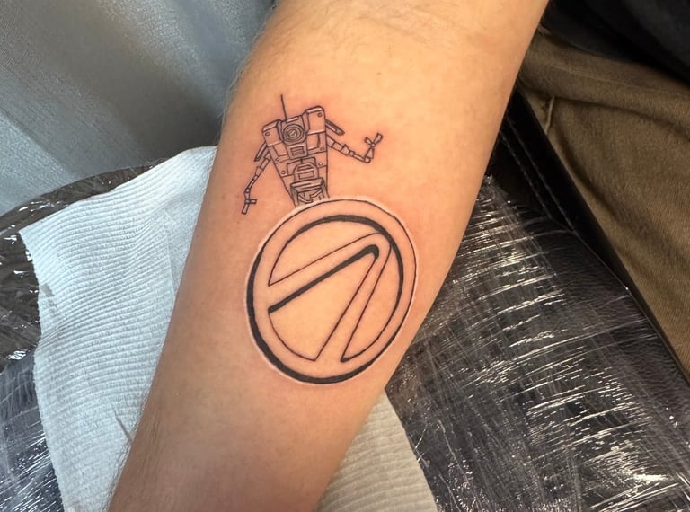 Arm tattoo featuring a robot above a circular geometric design with a diagonal line through it