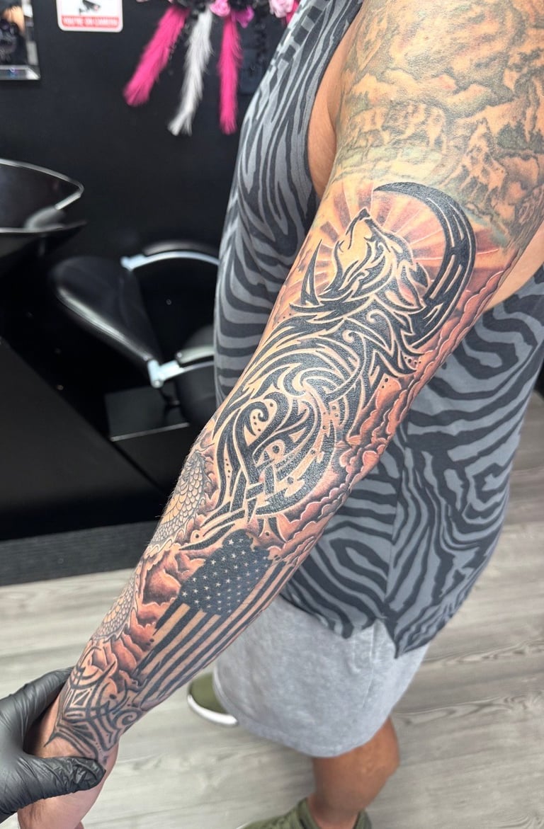 Full sleeve tattoo featuring intricate black and brown designs including abstract patterns and geometric elements on a person's arm