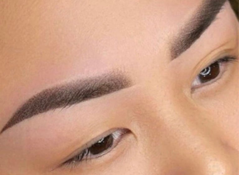 Close-up of a persons eyebrows and eyes showing full dark eyebrows and defined eye makeup